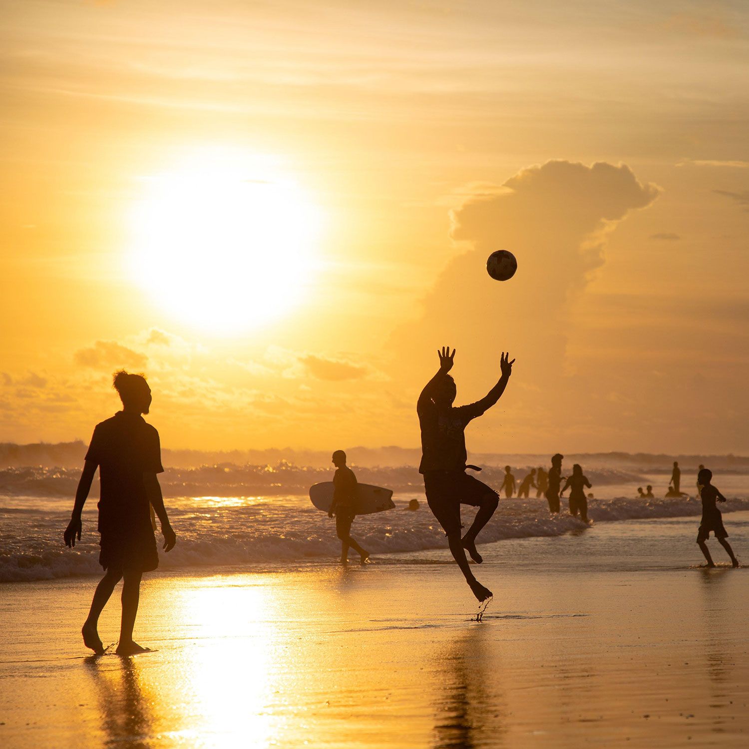 Ballspiel bei Sonnenuntergang am Strand